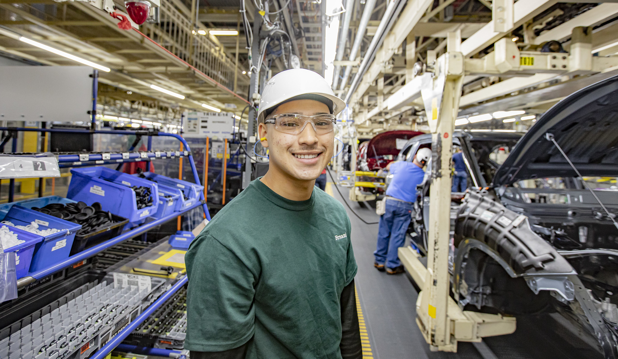 Picture of a Toyota team members on the assembly line, smiling at camera